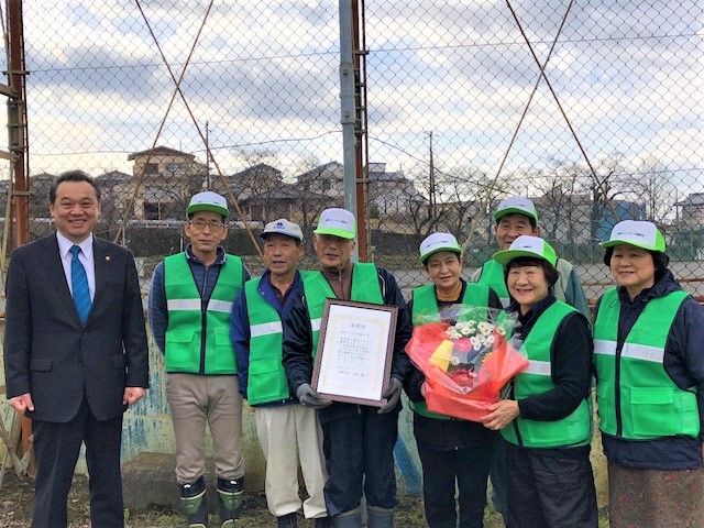 裾野ウォーキング健康会が賞状と花を持ち市長と写った写真